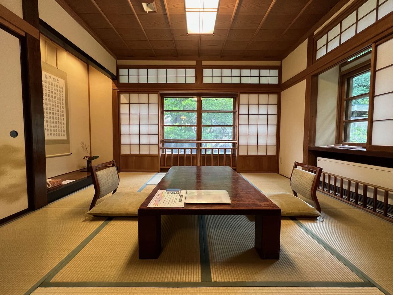 Une pièce de style japonais traditionnel, avec un sol recouvert de tatamis, une basse table en bois et des portes coulissantes en papier de riz (shoji).