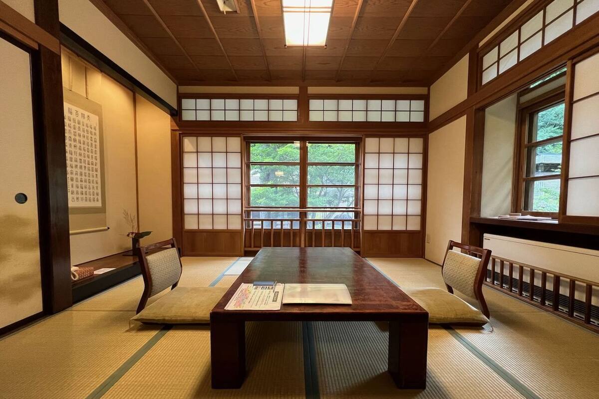 A traditional Japanese room with tatami flooring, a low wooden table, and sliding shoji doors.