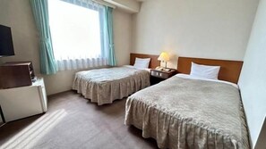 A hotel room with two beds, a desk, and a television. - Sky Hotel (Matsuyama)