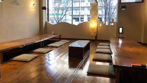 Ein modernes Interieur mit Holzböden, Sitzbereichen und großen Fenstern mit Blick auf Gebäude.
