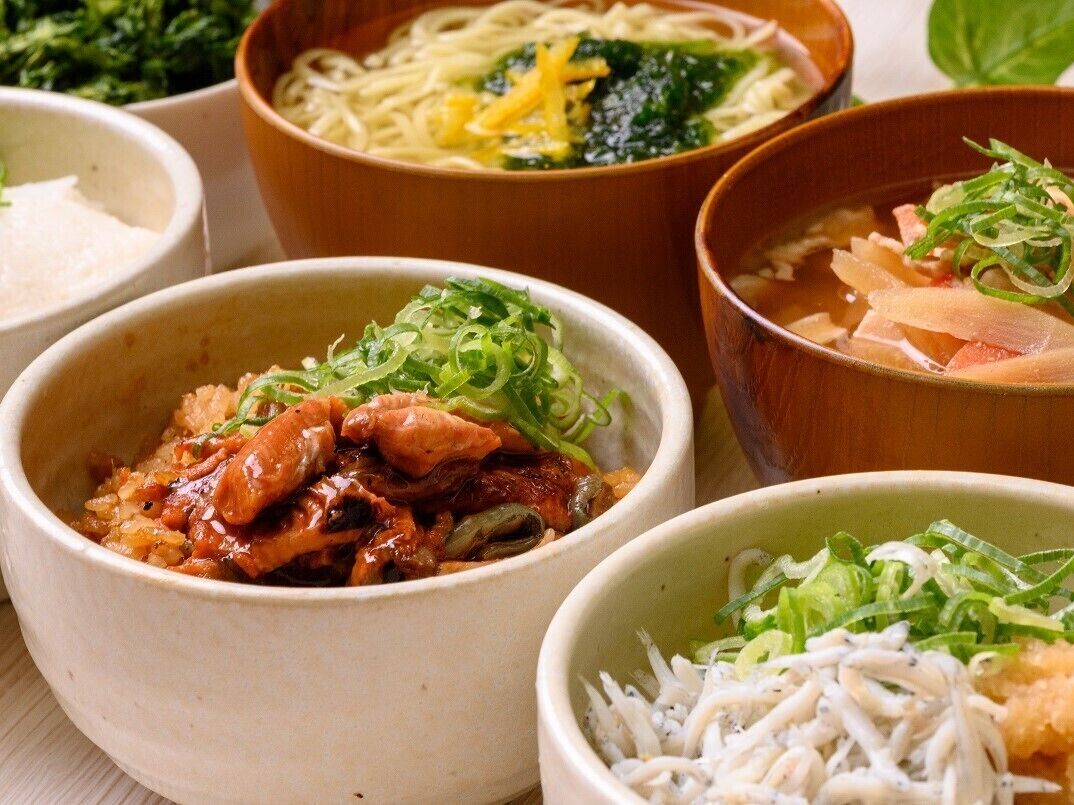 On propose une variété de plats servis dans des bols, comprenant différents types de cuisine asiatique, notamment des nouilles, des légumes et, éventuellement, des plats à base de viande.