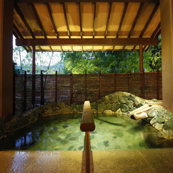 A traditional Japanese-style garden with a stone pond, wooden fence, and a wooden walkway. - Yugawara Ohnoya Ryokan (Atami)