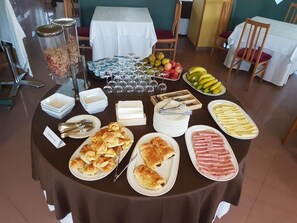 A buffet table with various food items and utensils. - Hotel Bello (O Pino)