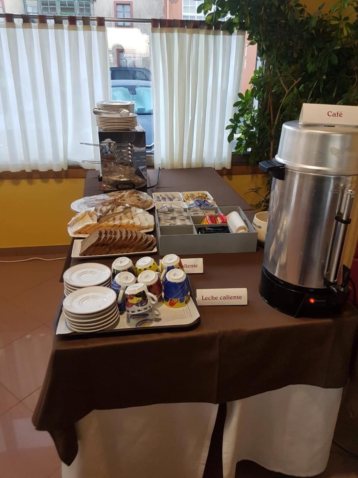 A buffet table with various food items and a coffee station.