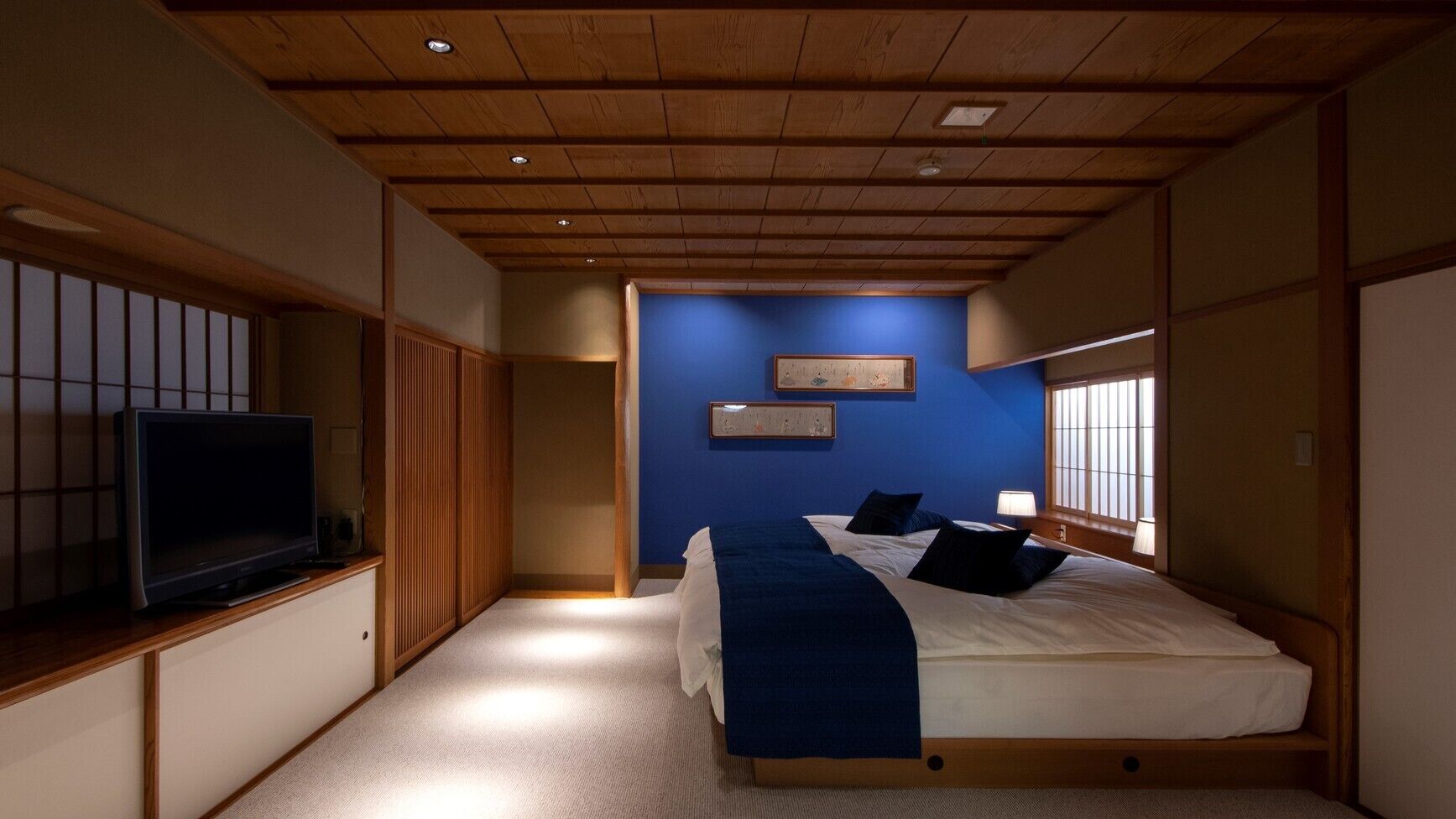 Un dormitorio con cama, televisión y ventana.