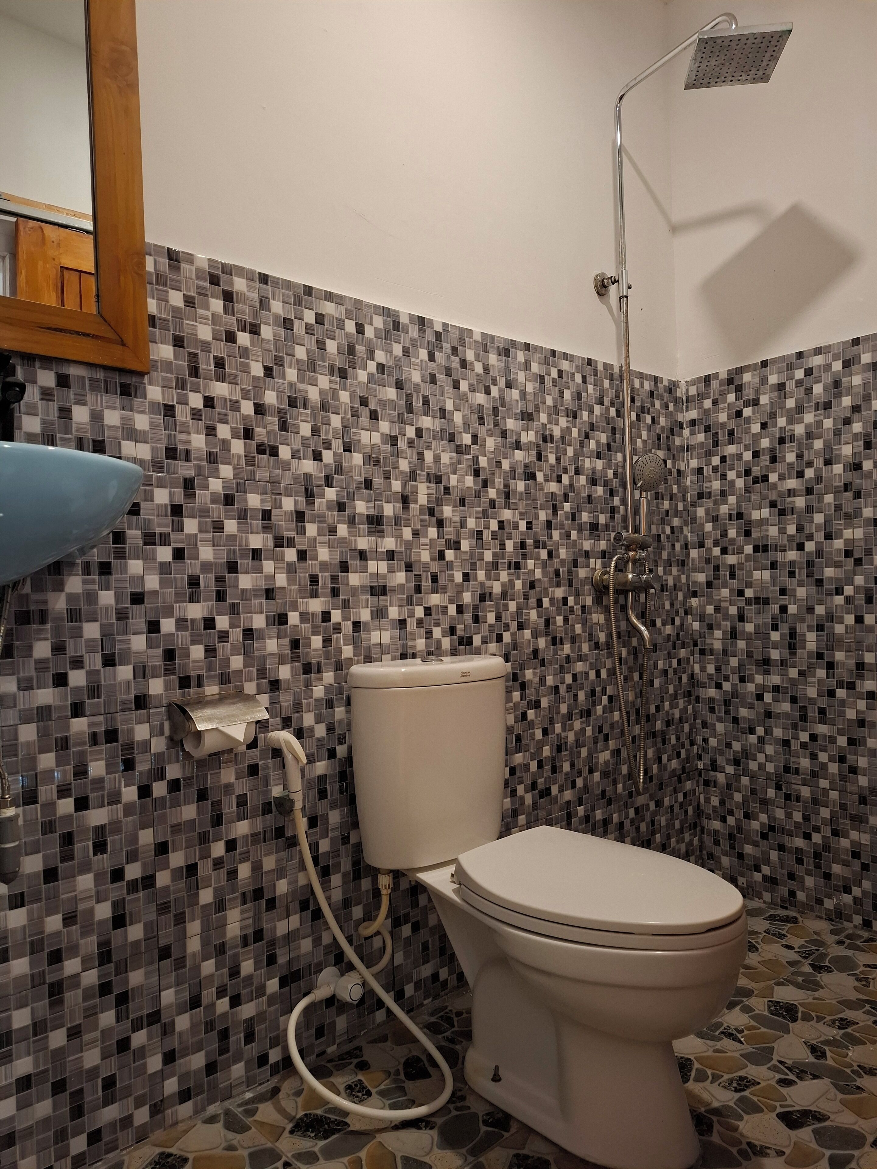 A bathroom with a toilet, a shower, and a sink.