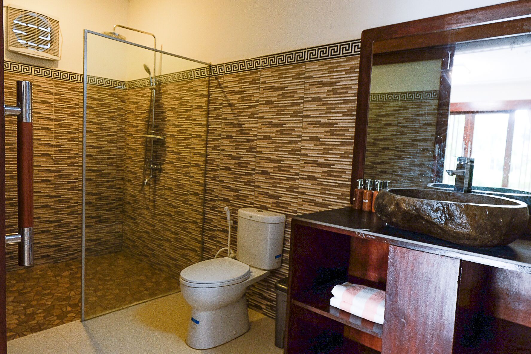 A bathroom with a shower, toilet, and sink.