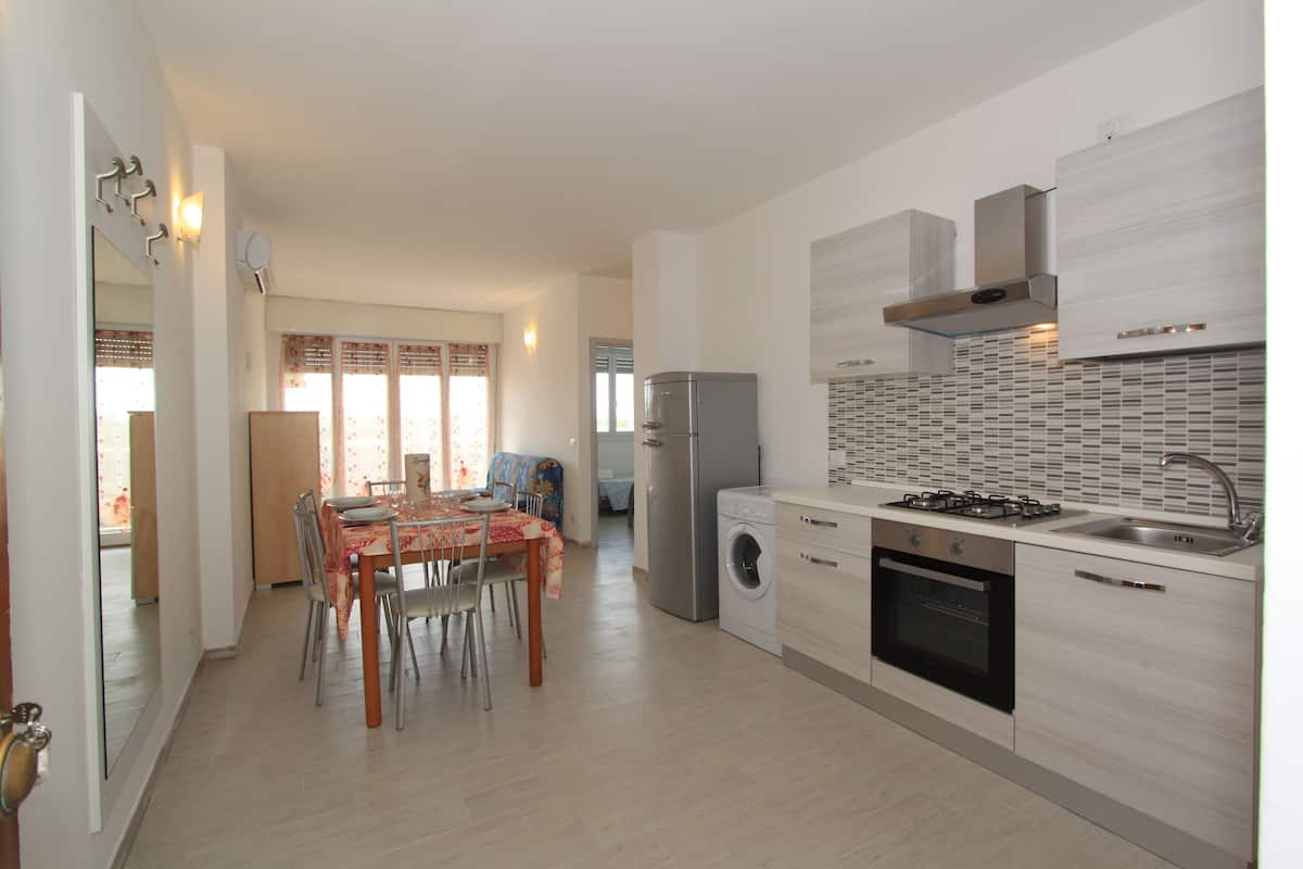 A modern kitchen with a dining area, stainless steel appliances, and a tiled backsplash.