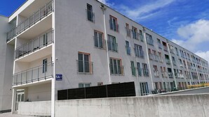 A modern multi-story building with balconies, a concrete barrier, and a clear sky. - Family Homes - Apartamenty Vento (Wladyslawowo)