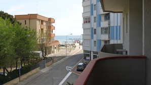 Vista de una calle con edificios, cielo despejado y una masa de agua distante.