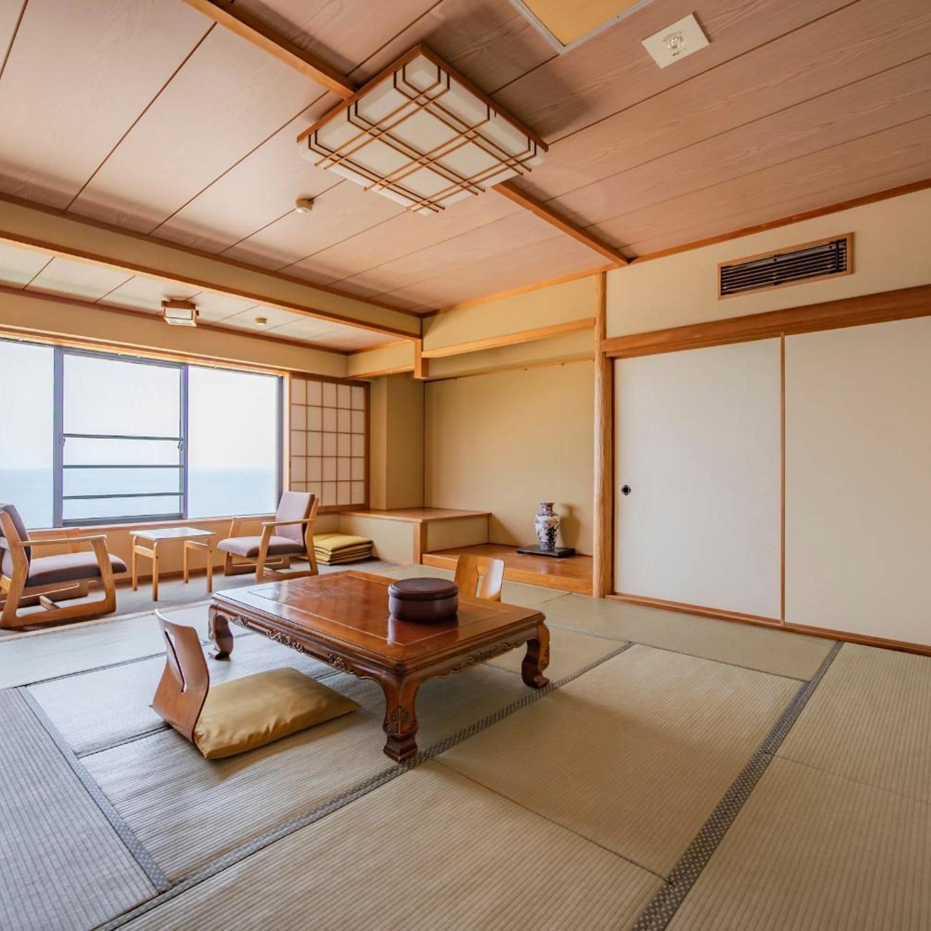 A traditional Japanese room with tatami flooring, a low wooden table, and sliding doors.