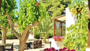A patio area with outdoor furniture, a pergola, and flowering plants. - Residence Rendez Vous (Vieste)