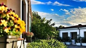 A courtyard with potted plants and a building with a tiled roof. - Residence Rendez Vous (Vieste)
