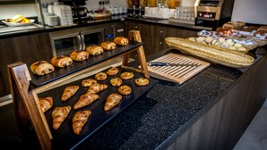 Un buffet della colazione con croissant e altri dolci in mostra.