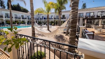 Una piscina al aire libre, sombrillas, tumbonas