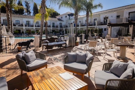Una piscina al aire libre, sombrillas, sillones reclinables de piscina