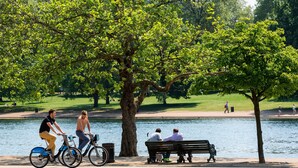 A park with a lake, bicycles, and a bench. - Hyde Park Radnor Hotel (London)