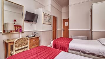 Een hotelkamer met twee bedden, een bureau, een stoel, een televisie en een spiegel.