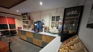 A modern kitchen with a central island, bar seating, and a display of pastries. - Fasthotel La Roche sur Yon Un FH CONFORT (La Roche-sur-Yon)