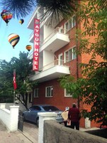 A hotel with a red brick facade, balconies, and a sign indicating it is a 'DAGUN HOTEL'.