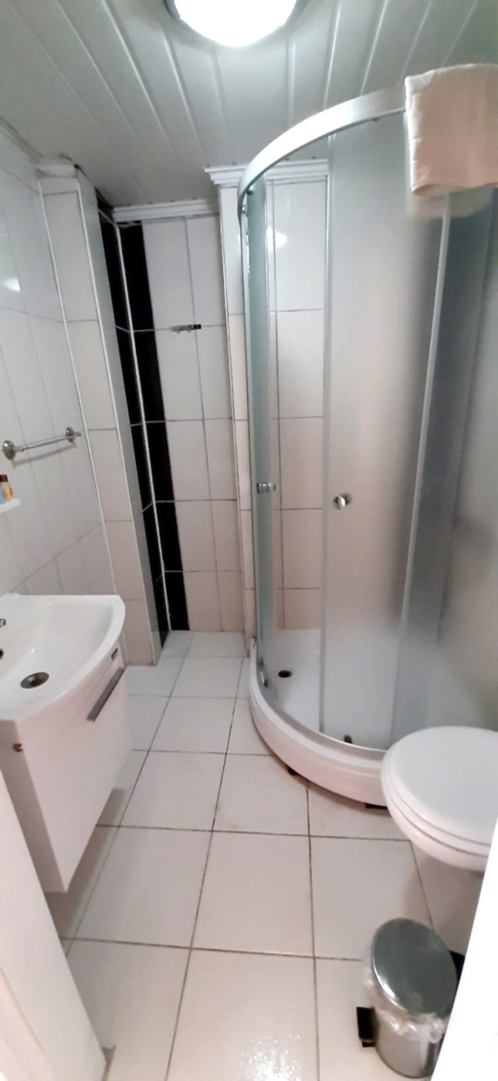 A bathroom with a shower, toilet, and sink.