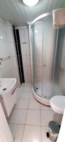 Un baño con ducha, inodoro y lavabo.