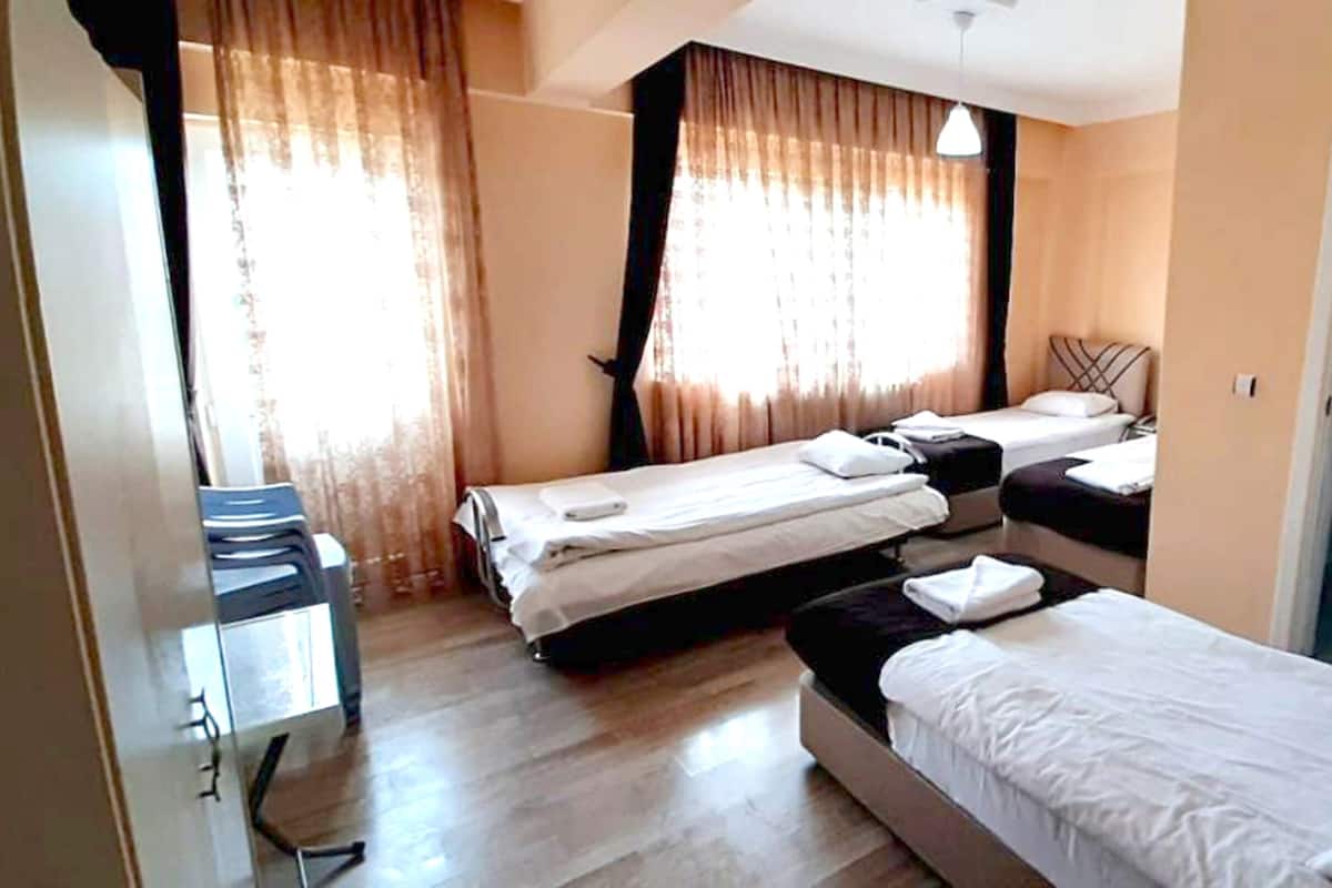 A hotel room with two beds, a desk, and a door.