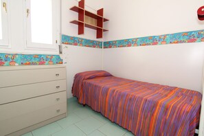 A bedroom with a bed, a dresser, a window, and a shelf. - Conchiglia Apartments (Comacchio)
