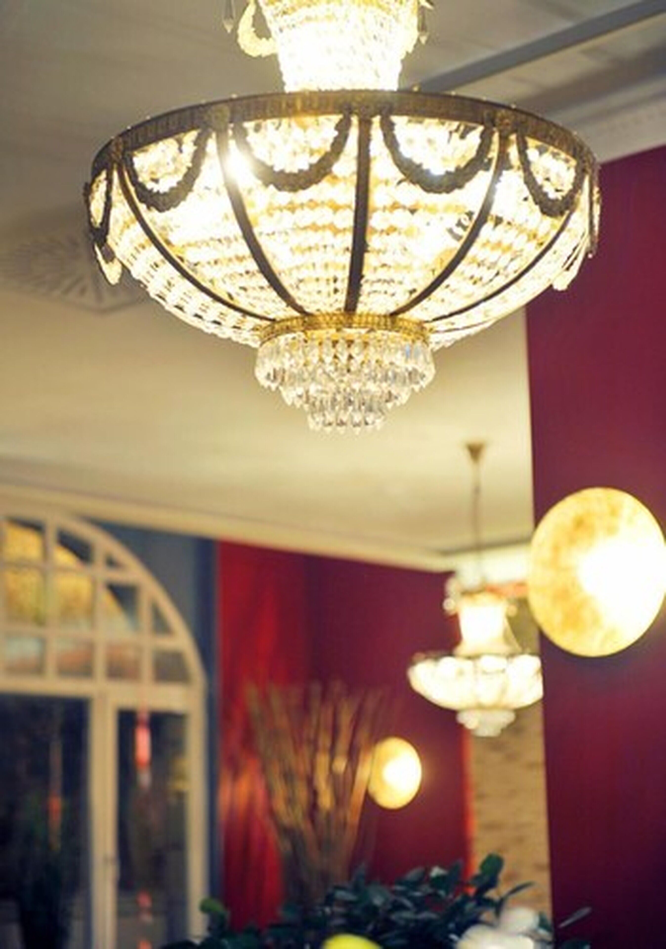A chandelier with multiple light sources and a reflective surface below.