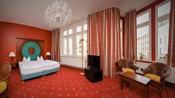Ein Hotelzimmer mit Bett, Fernseher, Schreibtisch und Stuhl.