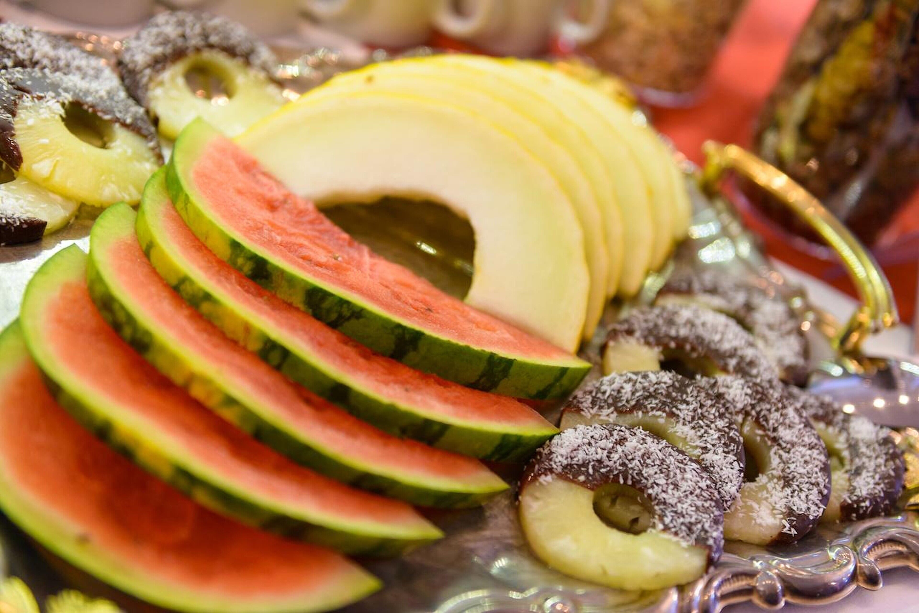 Diversitat de fruita tallada i fruits secs presentats sobre un plat decoratiu.