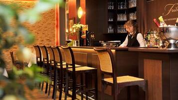 Een bar met houten stoelen en een barman.