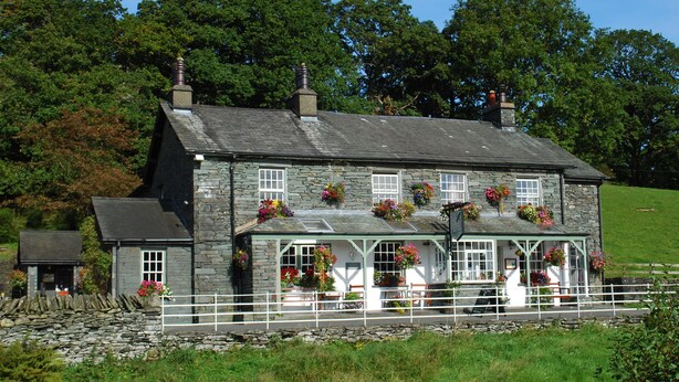 A stone house with a white porch and flower boxes. - The Three Shires Inn (Ambleside)