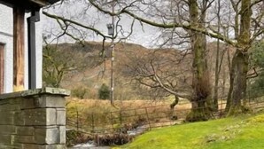 A stone building with a small stream flowing over rocks. - The Three Shires Inn (Ambleside)