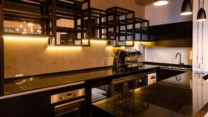 A modern kitchen with built-in appliances, a central island, pendant lighting, and a backsplash with geometric patterns. - hUB Antofagasta (Antofagasta)