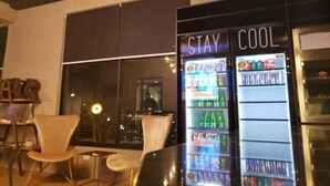 A modern interior with a vending machine labeled "STAY COOL" and a seating area with chairs. - hUB Antofagasta (Antofagasta)