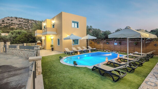 Ein moderner Poolbereich mit einem rechteckigen Pool, Liegestühlen und Sonnenschirmen.