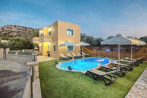 A modern pool area with a rectangular pool, lounge chairs, and umbrellas. - Lindos Luxury Retro Villas (Rhodes)