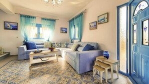 Ein Wohnzimmer mit einer Couch, einem Couchtisch und einer blauen Tür mit dekorativen Glasfeldern.