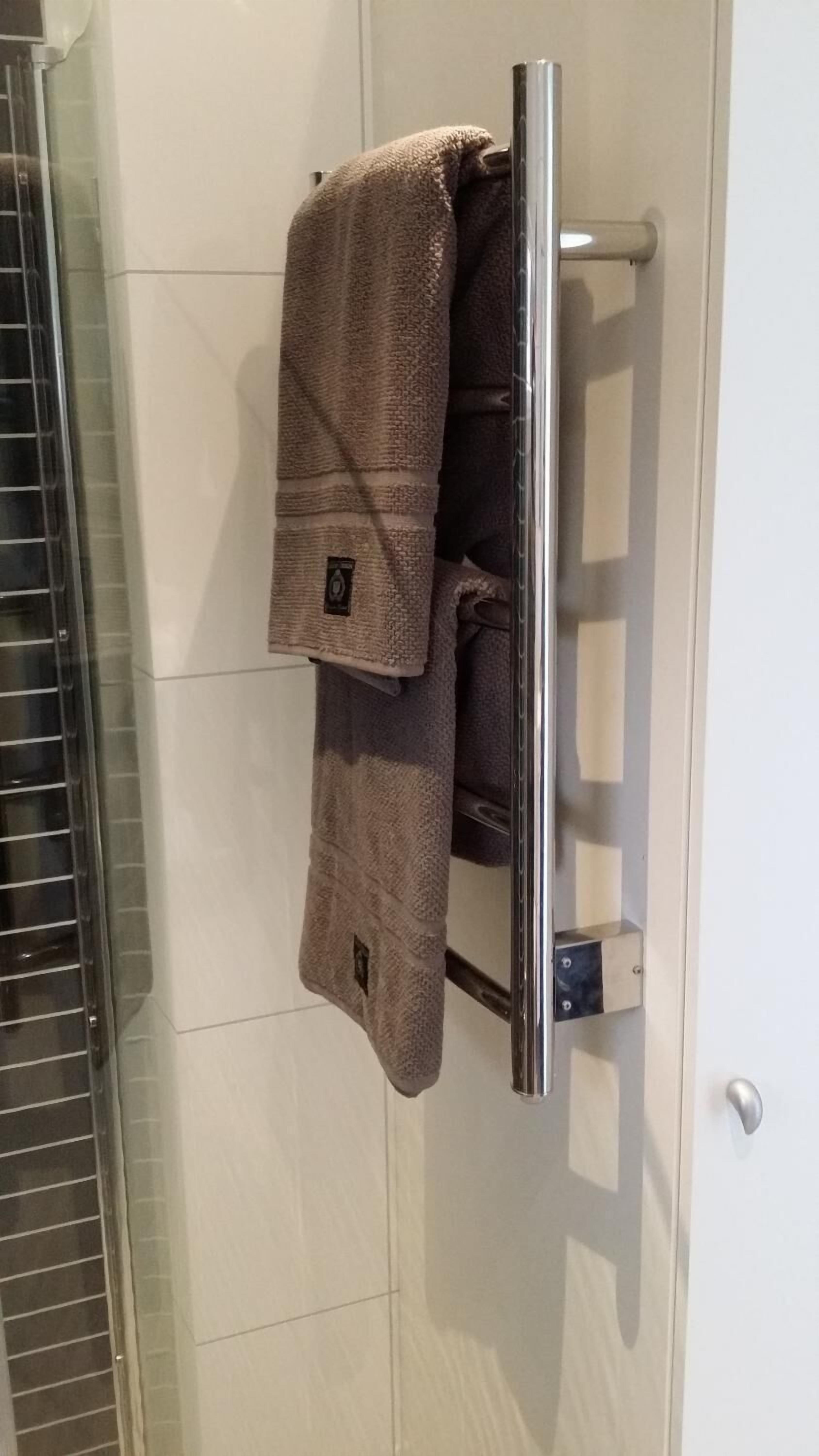 A bathroom with a towel rack holding two towels.