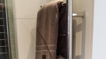 A bathroom with a towel rack holding two towels.