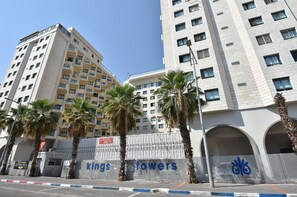 A multi-story building with a modern architectural design, featuring a prominent 'kings towers' sign.