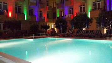 Una piscina al aire libre de temporada, sombrillas, tumbonas