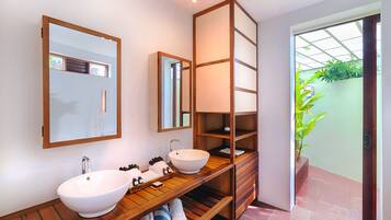 Un baño moderno con dos lavamanos, repisas de madera y un espejo grande.
