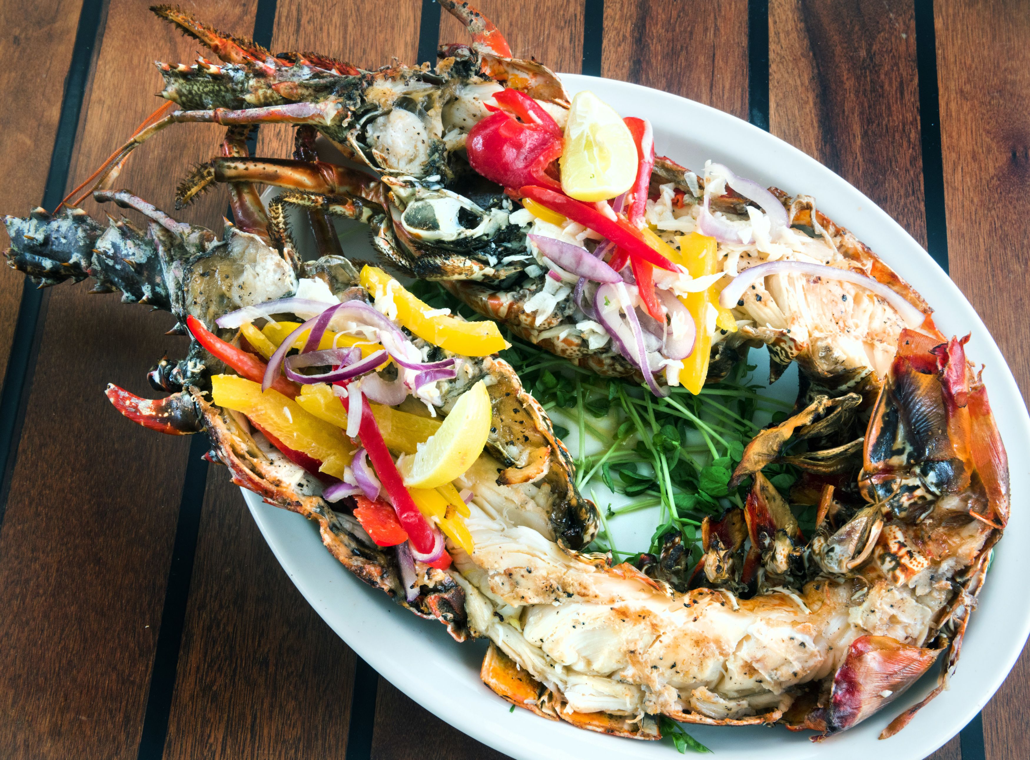 A lobster dish with vegetables on a white plate.