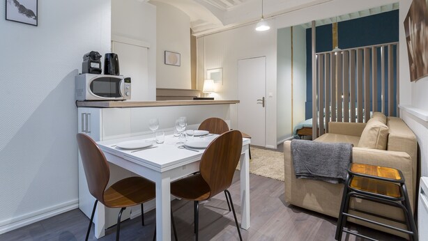 A modern kitchen with a microwave, coffee maker, and dining table set for four. - Up to 6 people in the heart of Old Lyon (Lyon)