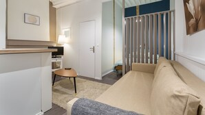 A modern living room with a sofa, a small table, a TV, and a door leading to another room. - Up to 6 people in the heart of Old Lyon (Lyon)