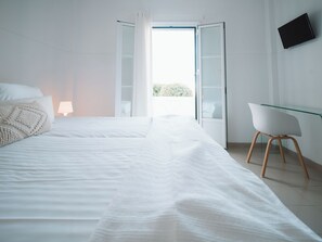 Un dormitorio moderno con una cama grande, un escritorio y una silla.