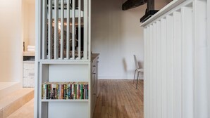 A hallway with a white bookshelf, a wooden floor, and a white chair. - Cozy cocoon on the heights of Old Lyon (Lyon)