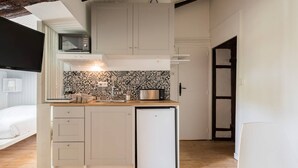 A compact kitchen with a microwave, toaster, and a small refrigerator. There is a wooden countertop and a patterned backsplash. - Cozy cocoon on the heights of Old Lyon (Lyon)